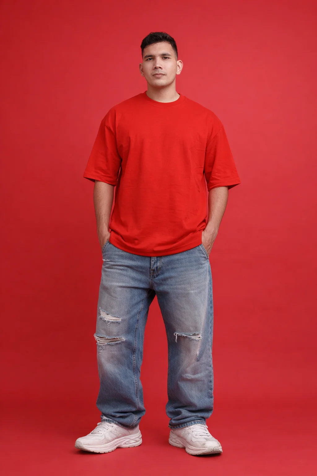Person wearing a red t-shirt and blue jeans on a red background