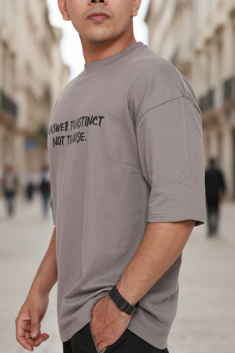 Man wearing a gray t-shirt with text on a blurred street background