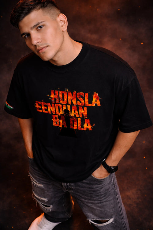 Person wearing a black t-shirt with colorful text against a dark background