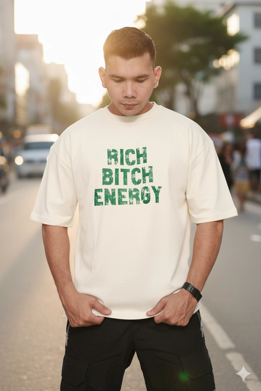 Person wearing a off white oversized t-shirt with green text on a street background