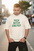 Person wearing a off white oversized t-shirt with green text on a street background