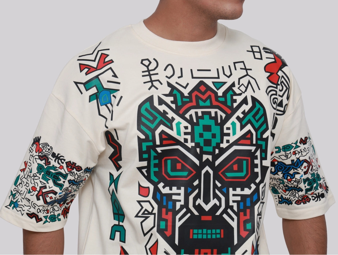 Person wearing a white hoodie with colorful geometric patterns on a plain background