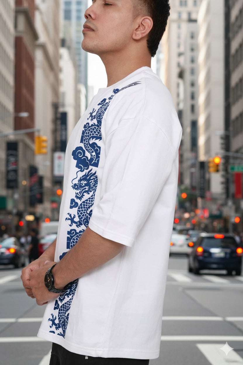 Man wearing a white shirt with blue dragon design oversized tshirt on a city street