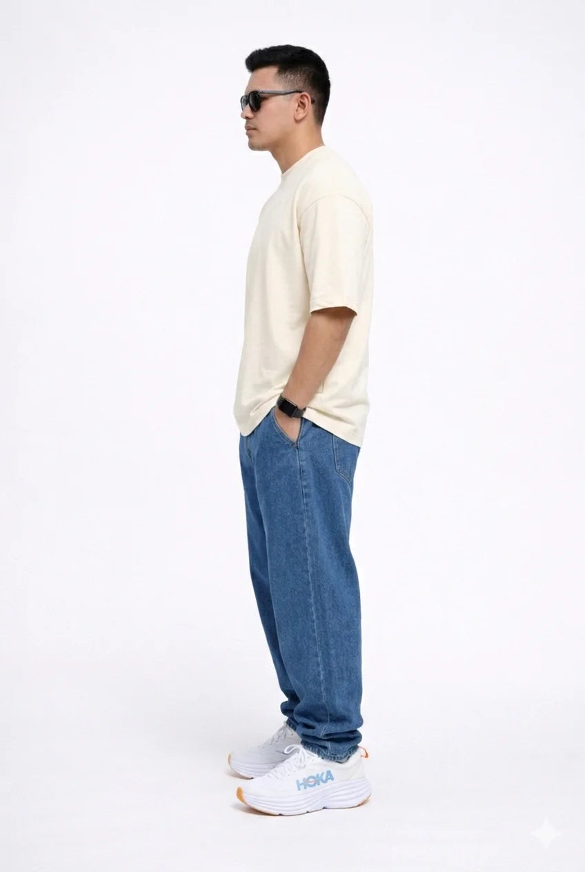 Man wearing a Off-white t-shirt, blue jeans, and white sneakers on a white background