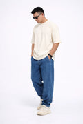 Man wearing a OFF WHITE t-shirt, blue jeans, and white sneakers on a white background
