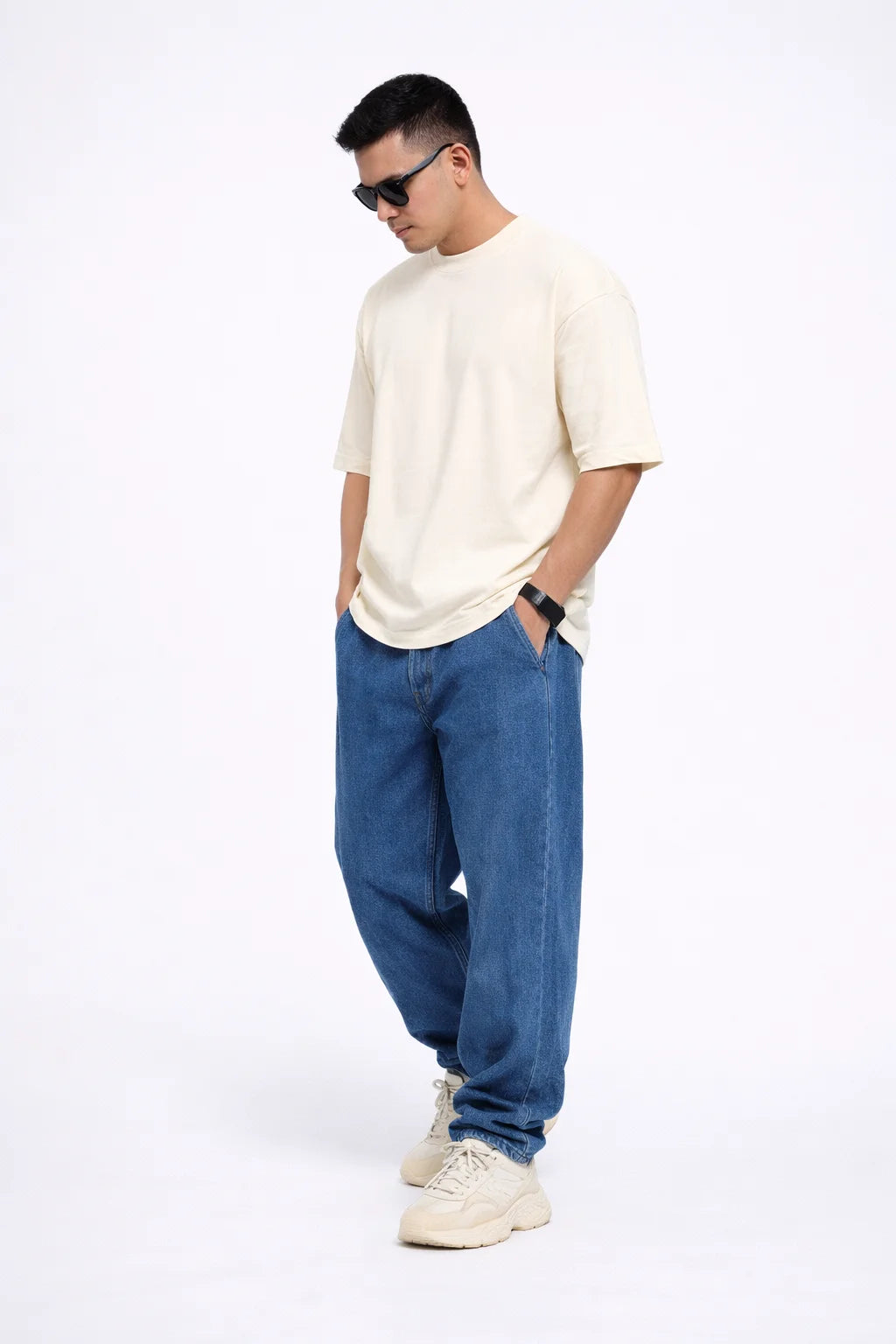 Man wearing a OFF WHITE t-shirt, blue jeans, and white sneakers on a white background