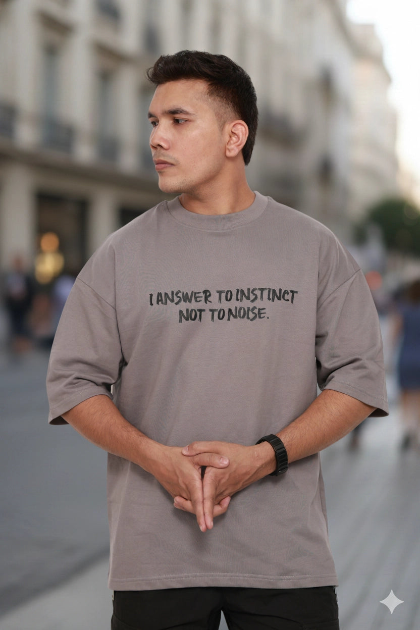 Man wearing a gray t-shirt with text on a city street
