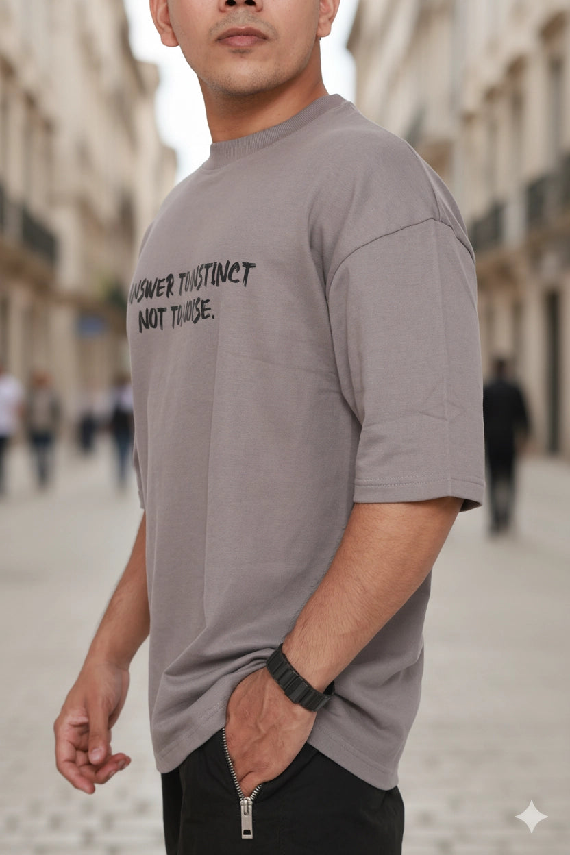 Man wearing a gray t-shirt with text on a blurred street background