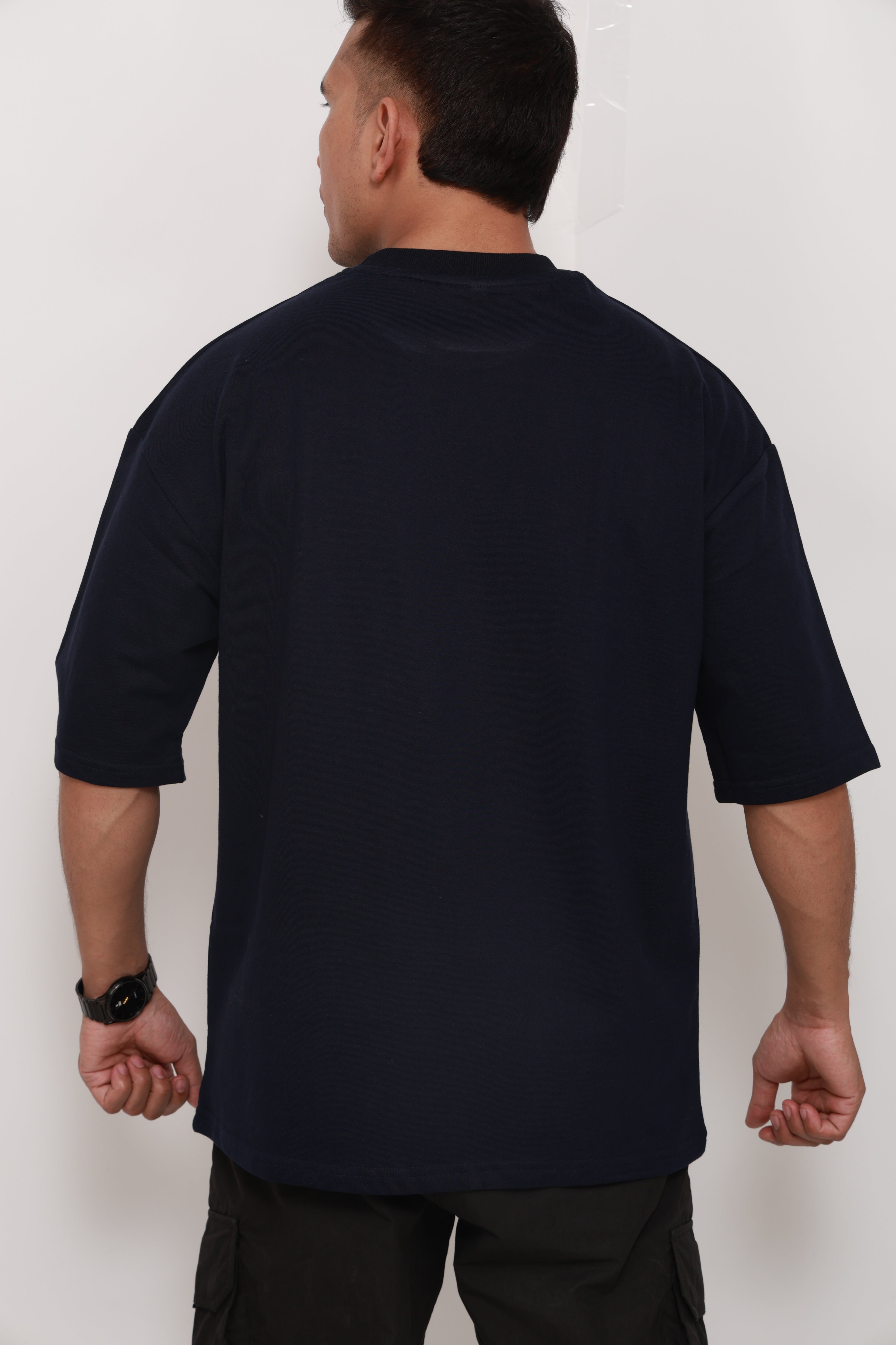 Person wearing a Navy BlueTshirt with a colorful graphic design of an artistic camel 