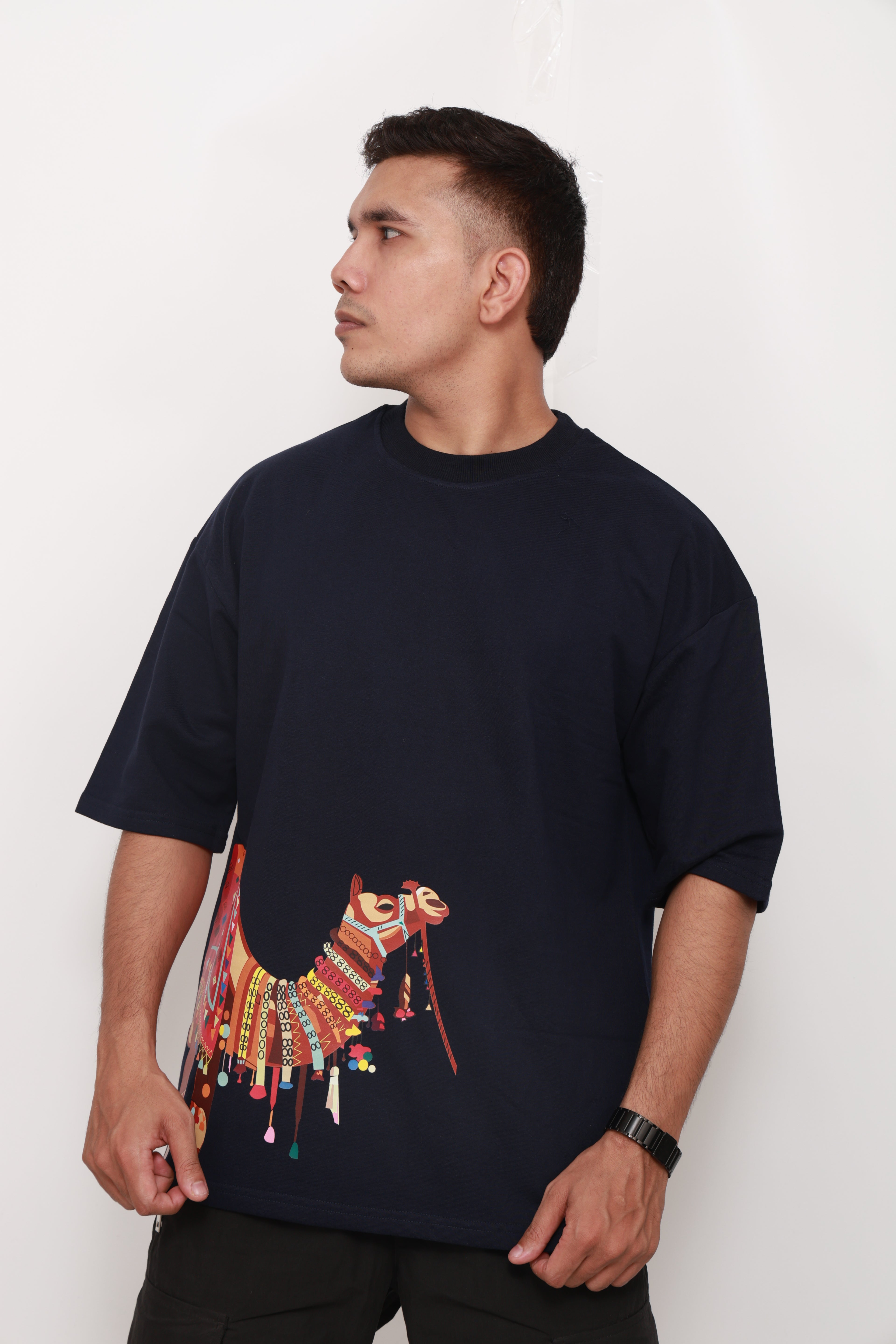 Person wearing a Navy BlueTshirt with a colorful graphic design of an artistic camel 