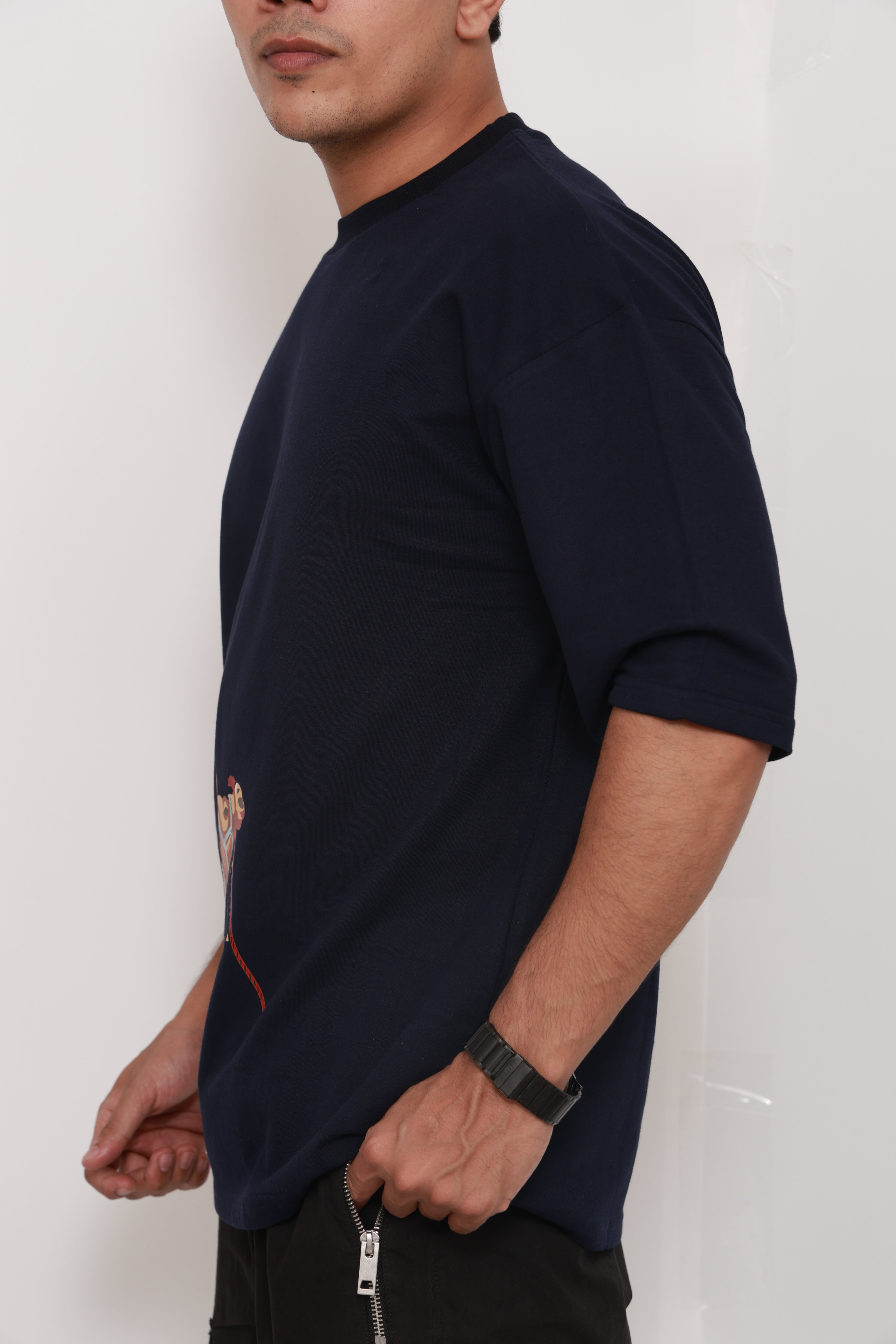 Person wearing a Navy BlueTshirt with a colorful graphic design of an artistic camel 