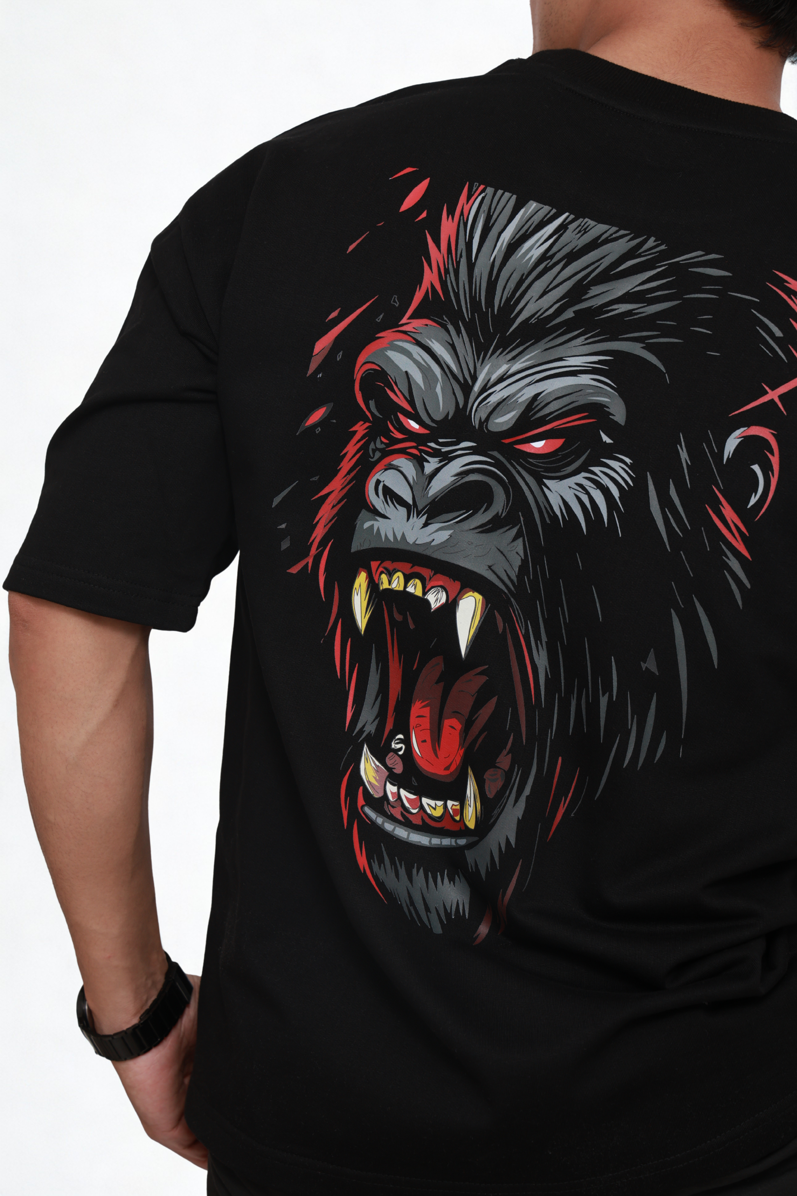 Black t-shirt with a graphic of a gorilla's face on the back, displayed on a person.