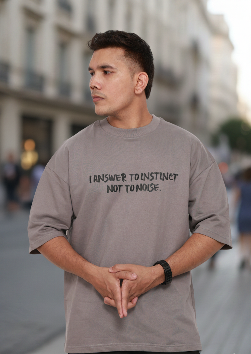 Man wearing a gray t-shirt with text on a city street