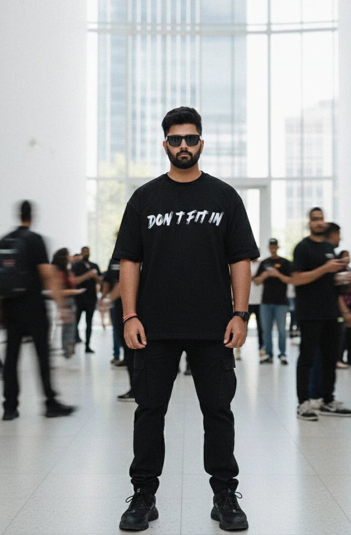 Man wearing a black t-shirt with text in a modern indoor setting