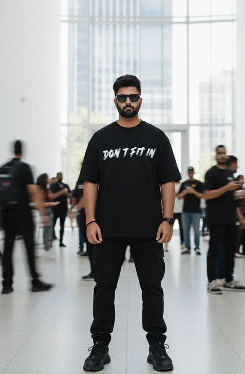 Man wearing a black t-shirt with text in a modern indoor setting
